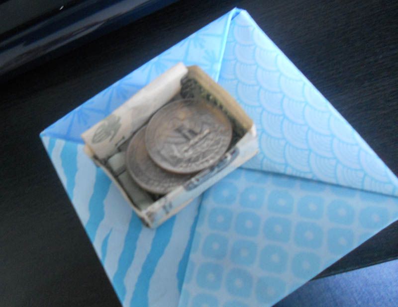 Quarters inside an origami dollar bill box