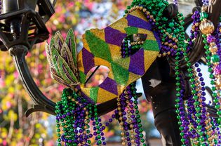 Outdoor Mardi Gras beads and mask on light post