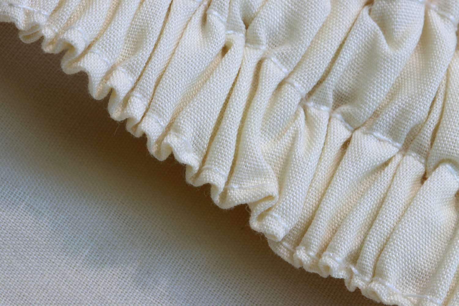 奶油色的棉织物通过弹力形成褶皱的图案