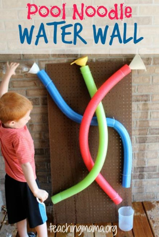 男孩使用池面水冷壁与红色,绿色和蓝色的面条、漏斗、杯。
