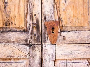 圣达菲风格:豆科灌木木门与生锈的锁孔(细节)
