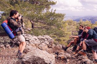 Woman photographing friends on hike