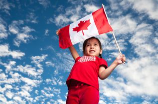 一个5岁的女孩拿着加拿大国旗微笑