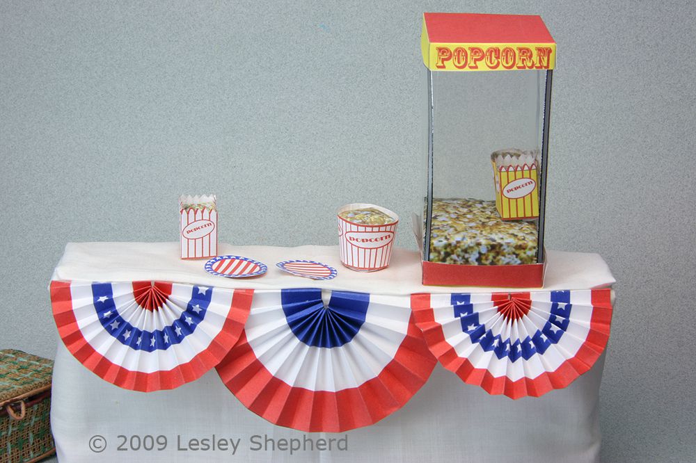Dollhouse scale table decorated for a fair with flag themed draping in red, white and blue.