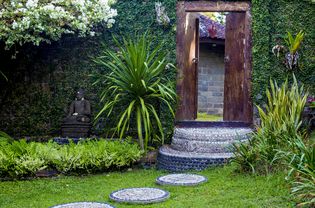 Door and Budha statue in the garden. Bali. Indonesia.