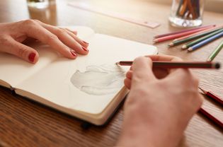 Woman sketching in notebook