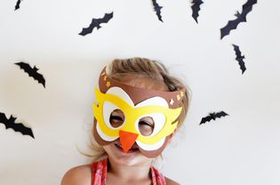 little girl wearing halloween owl mask