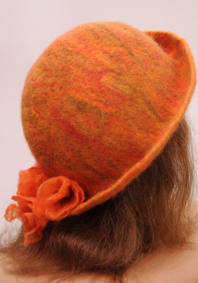 一个女人头上戴着一顶橙色的湿毡帽