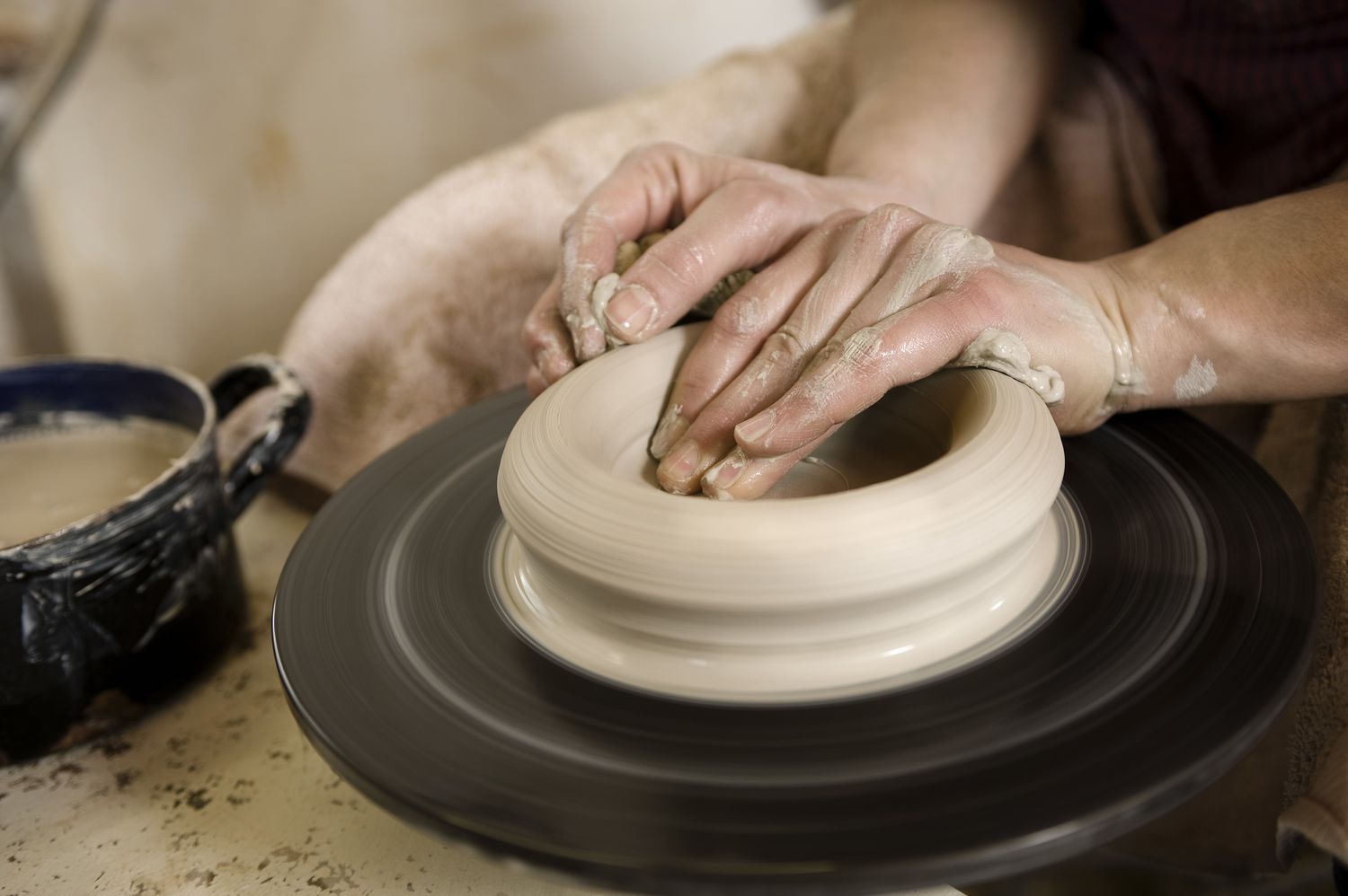 德国，巴伐利亚，中年成年妇女在陶工的轮子上摆弄粘土