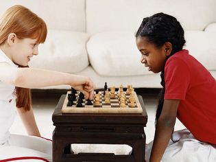 两个女孩在客厅玩国际象棋的游戏