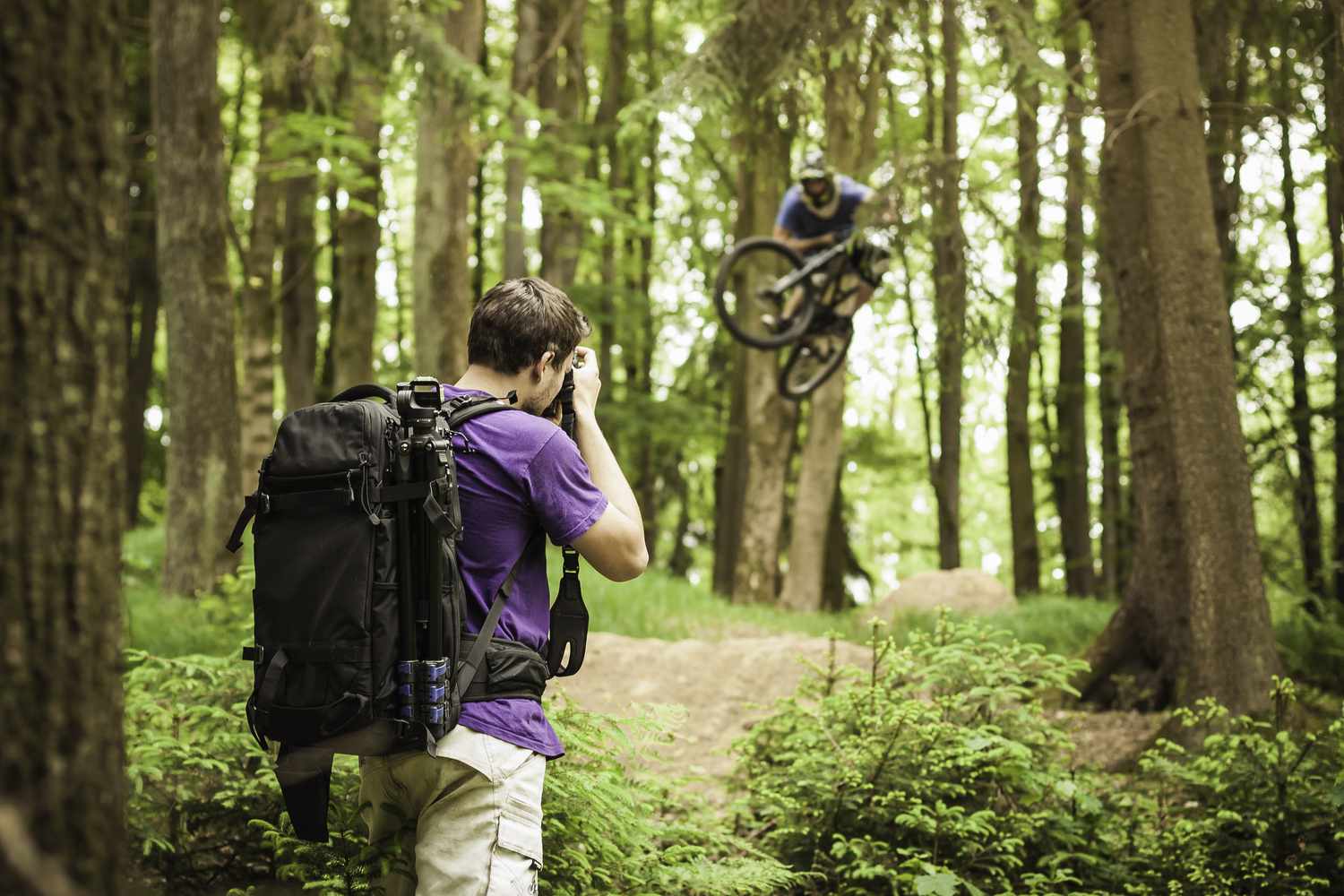 年轻男性摄影师拍摄森林山地自行车