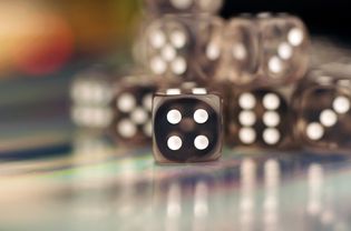 Clear Dice With Shallow Depth of Field, Die Displaying Number Four in Focus