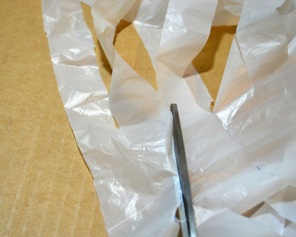 剪刀削减塑料袋成条状。
